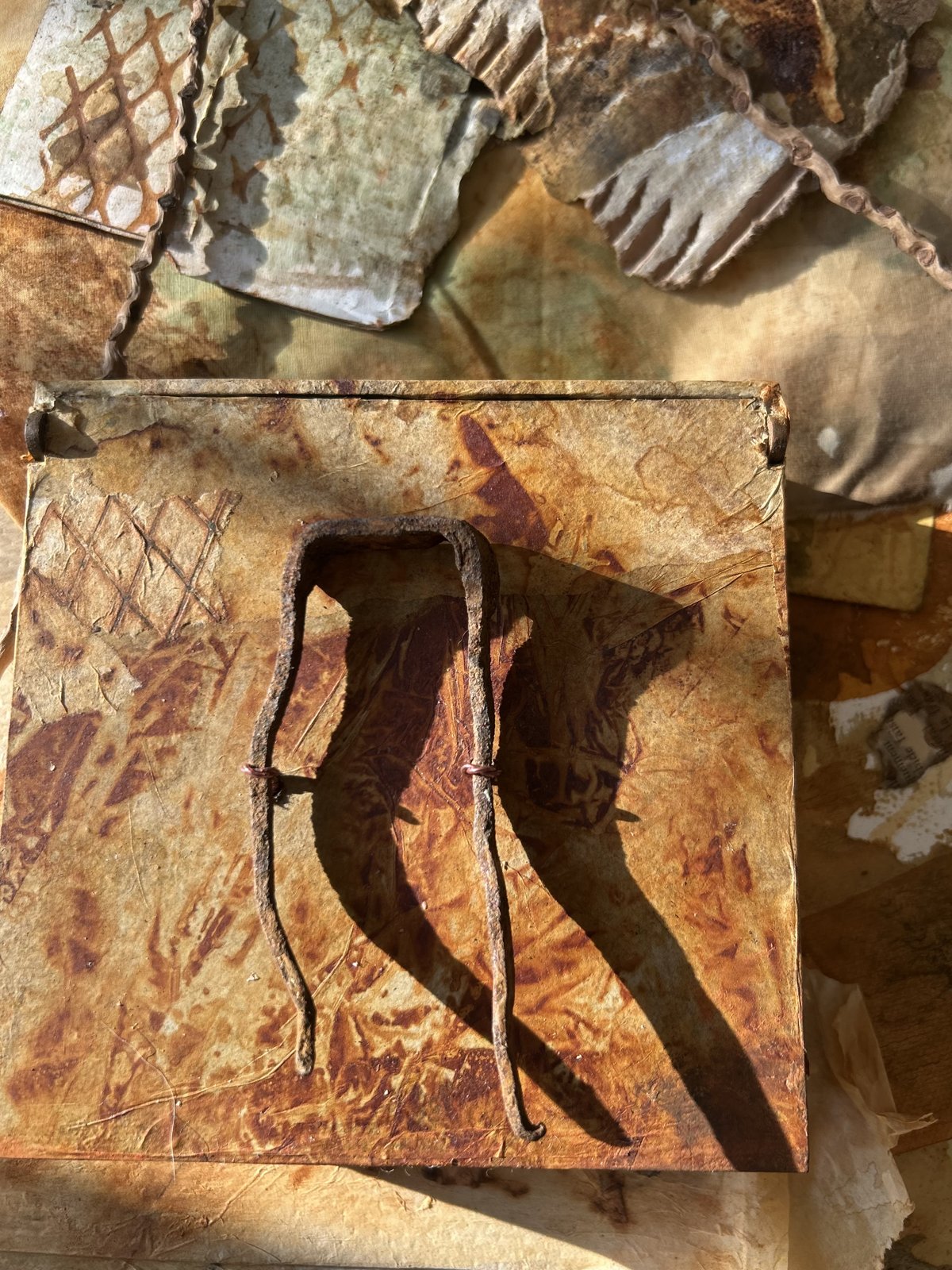Arte objeto oxidado: caja y papel con marcas de metal
